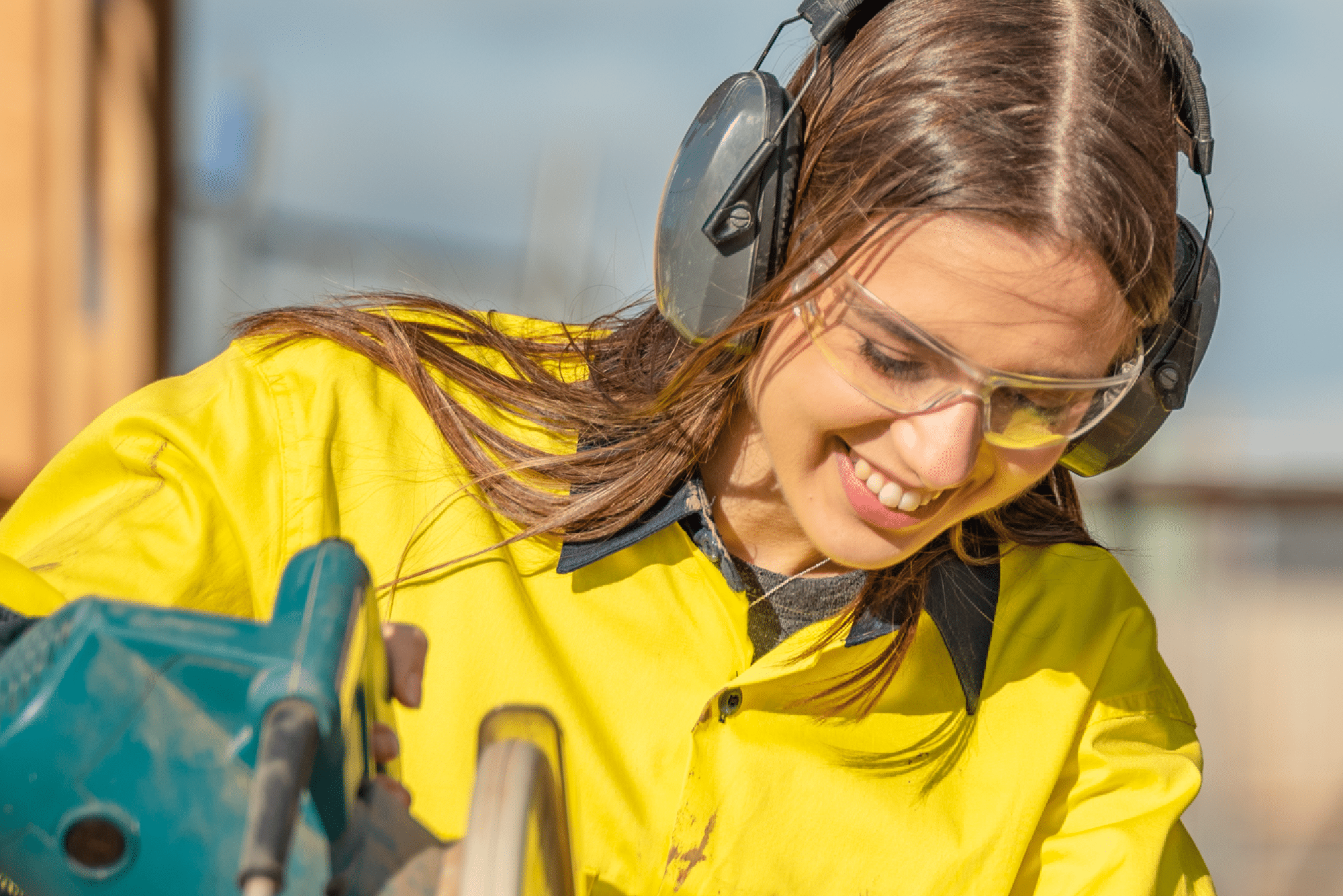 female construction student wearing hearing and eye protection while working